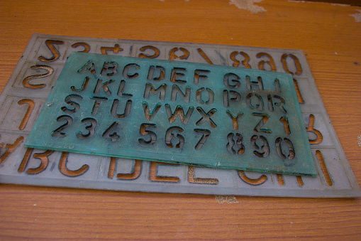 Old alphabet ruler placed on brown table