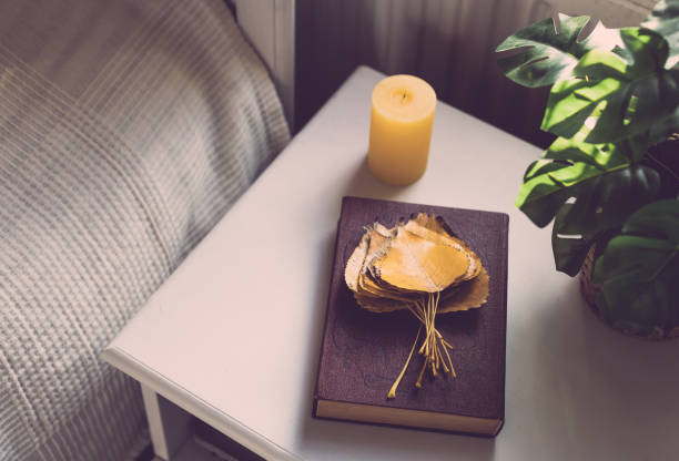 istock Book with leaves and candles on the bedside table. 1437071363