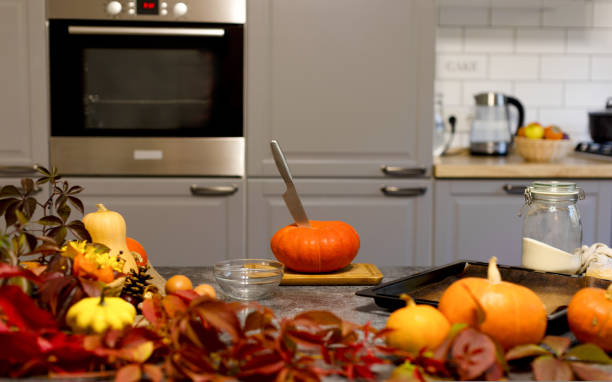 istock On the table is an orange pumpkin with a knife stuck in it. Kitchen. 1437071855