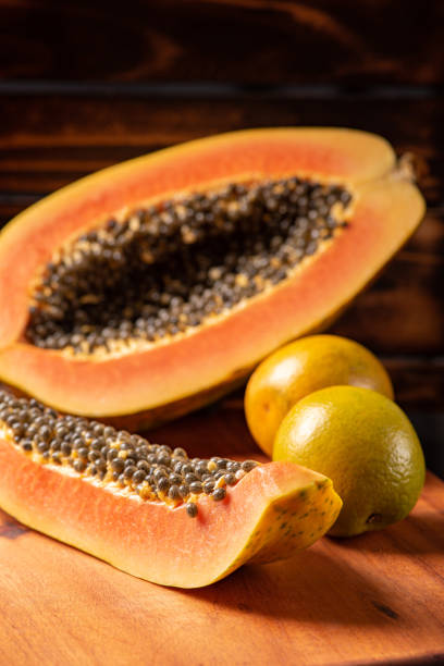 istock Papaya and oranges, scene with sliced papaya and oranges over rustic wood, selective focus. 1437073192