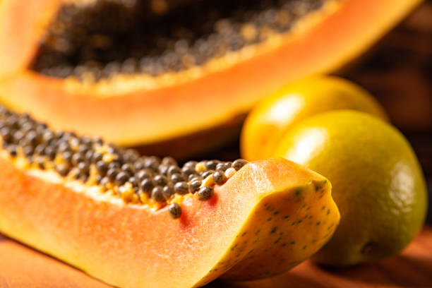 istock Papaya and oranges, scene with sliced papaya and oranges over rustic wood, selective focus. 1437073193