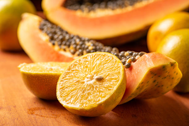 istock Papaya and oranges, scene with sliced papaya and oranges over rustic wood, selective focus. 1437073208