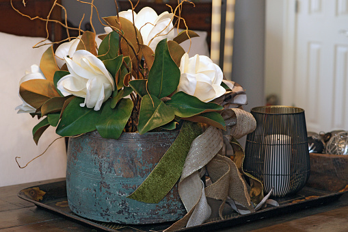 An antique blue crock is the perfect container for magnolias and Christmas ribbons.