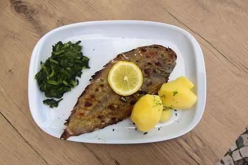 Traditional Portuguese grilled sole dinner served with spinach and boiled potatoes.