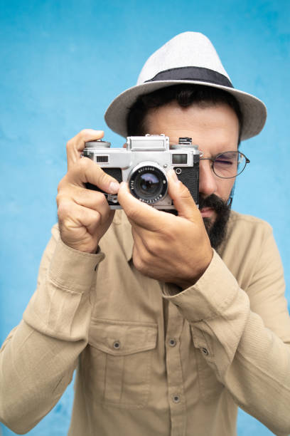 istock A young hipster man with hat is making a photo with a retro camera 1437077190