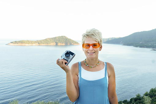 Portrait of a woman with a vintage camera looking at camera