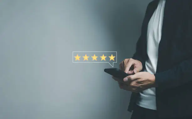 Photo of Customer give a rating five star to service experience on smartphone, evaluate the quality of service to reputation ranking of the business. client satisfaction feedback review survey concept,