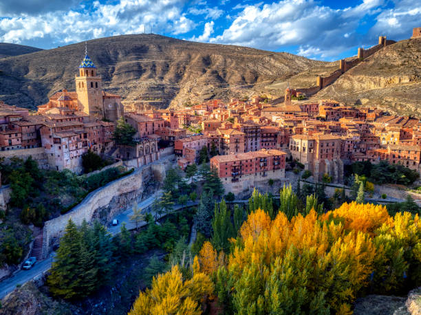 Views of Albarracin at sunset with its walls and its cathedral in the foreground.