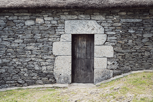 Stone wall and wooden door in Galicia, Spain.