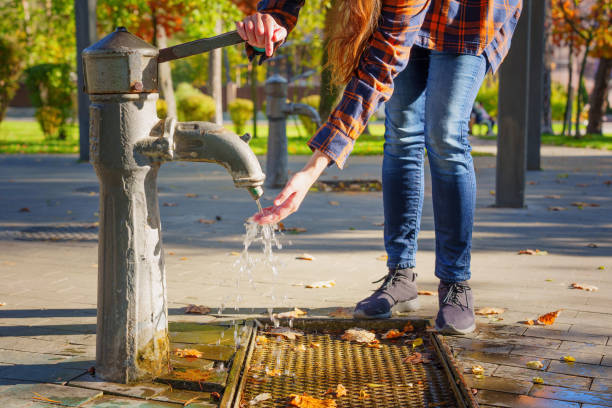 istock Female using a public water pump in the park 1437081731