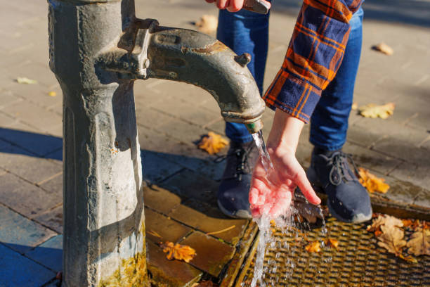 istock Using a drinking water hand pump outdoors 1437081770