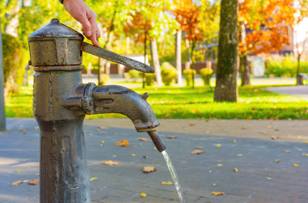 istock Using hand pump of the drinking well 1437081800
