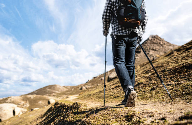 Travelling alone in the mountains. Close-upshot of man hiking alone in the mountains at sunny weather