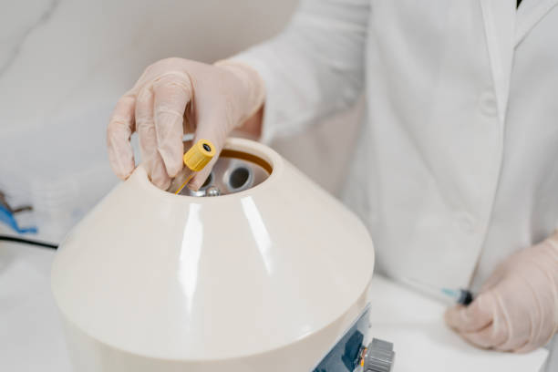 istock Female Doctor Putting Blood Samples In A Centrifuge Machine 1437090380