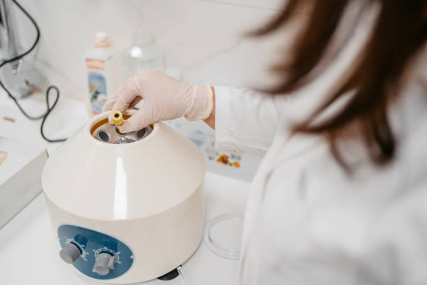 istock Female Doctor Putting Blood Samples In A Centrifuge Machine 1437090406