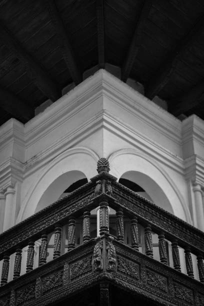 Vertical greyscale shot of a colonial building with balcony in Cusco, Peru