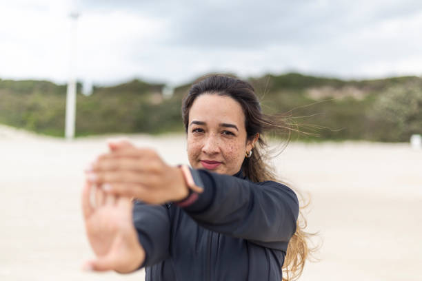 istock Latin woman performing physical exercises on the beach 1437093515