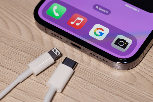 view of apple iphone with both usb-c and lightning cable charger. eu forced Apple iphone to Use usb-c instead of lighting cable in 2024
