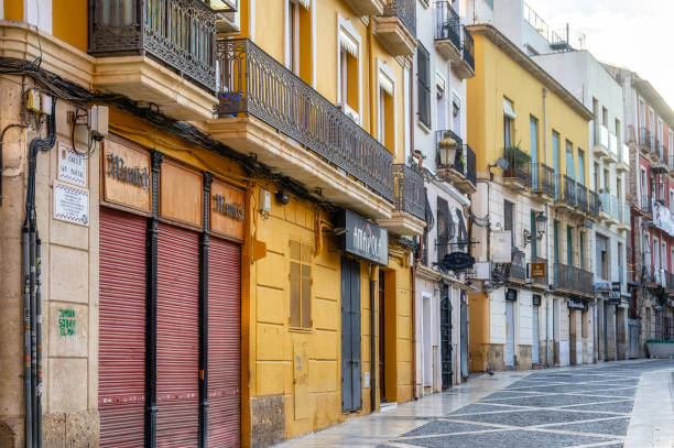 Alicante, Spain - September 29, 2022: An empty sidewalk in an urban area. Story buildings with balconies line one side of the walkway, and no people are on the scene.