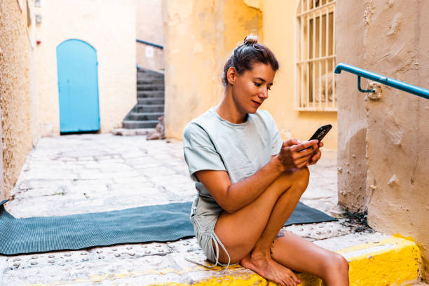 istock Young Caucasian woman using mobile phone in Middle Eastern old city 1437103732