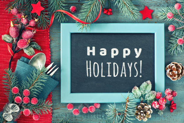 istock Decorated dark background with red and green decorations, fork and spoon, text Happy Holiday on blackboard, chalk board. 1437105364