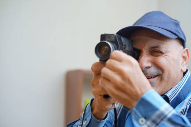 Using a Super 8 Movie Camera A man use a Super 8 film camera in his home. vintage amateur movie camera stock pictures, royalty-free photos & images