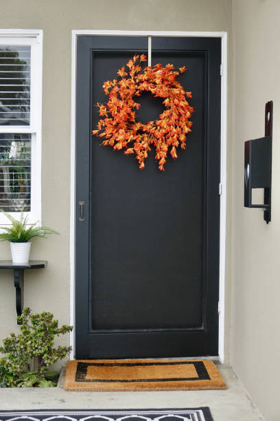 la corona de otoño adorna la puerta principal de esta cabaña - screen door door porch house fotografías e imágenes de stock