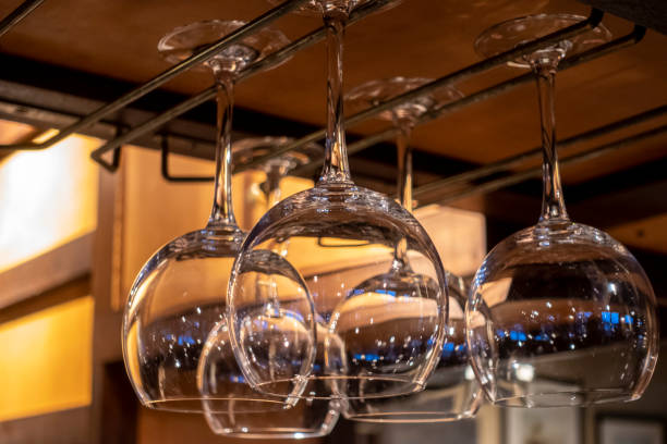 vista ravvicinata dei bicchieri di vino appesi sopra un bancone del bar in un ristorante - cocktail transparent cocktail shaker glass foto e immagini stock