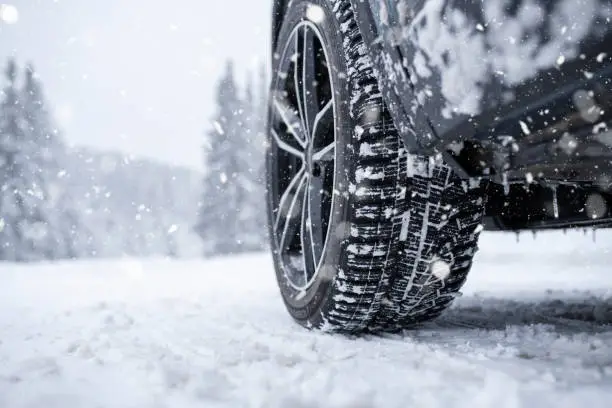 Photo of Car tyre on a snowy road in winter.