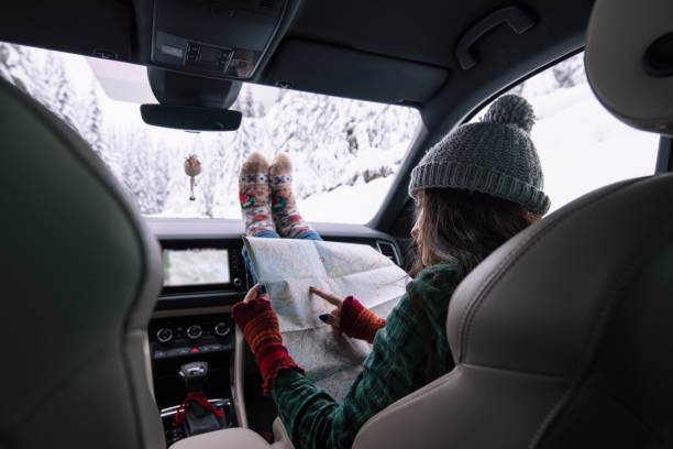 istock Woman on winter road trip reading map for directions. 1437124845