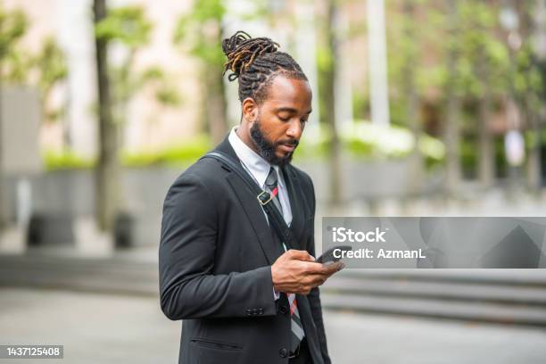 Black Male Lawyer Texting And Walking Outdoors Stock Photo - Download Image Now - Lawyer, Text Messaging, Outdoors