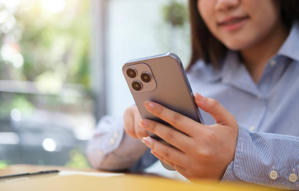 istock Close up view female employee taking a break from work and using mobile phone. 1437136116