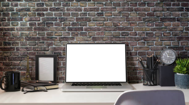 istock Front view laptop computer, stationery, picture frame, house plant and coffee cup on white table. Stylish workplace. 1437136734