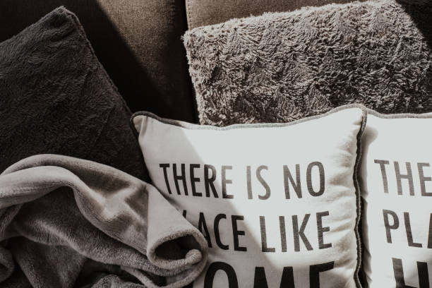 There is no place like home saying on decorative pillows in dark grey and white colors