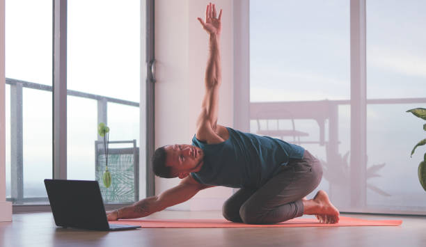 istock Latin man stretching at home following internet videos 1437149563