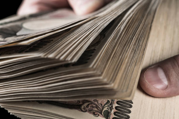 istock A person holding a stack of Japanese banknotes and counting them. 1437149633