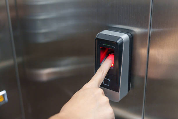 istock Woman using finger to fingerprint scanner in Elevator. Security system in office and apartment concept 1437153684