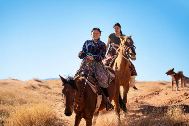 soeurs navajos conduisant sur des chevaux dans monument valley arizona - navajo reservation photos et images de collection