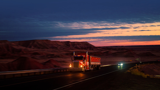 Red semi truck driving at blue hour in Arizona, USA
