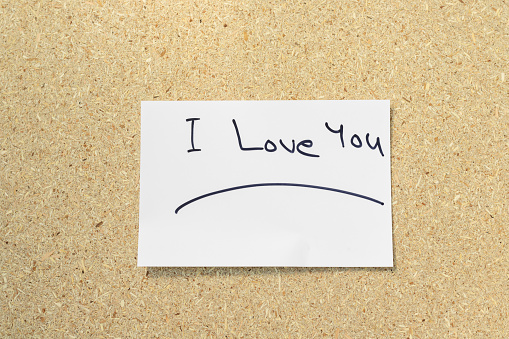 I love you phrase handwritten on a white post card with copy space