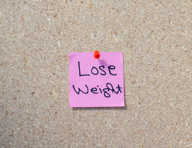 istock Lose weight hand written reminder on a sticky note pasted on a notice board 1437168714
