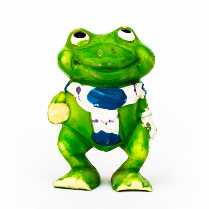 Statuette of a green frog close-up on a white background.