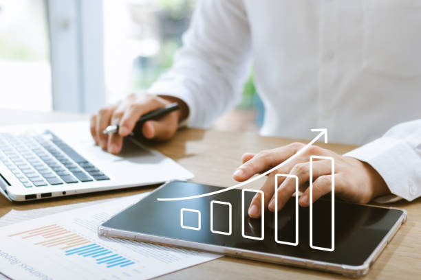istock Businessman analyzing company's financial balance sheet working with digital augmented reality graphics. Businessman calculates financial data for long-term investment. 1437174320