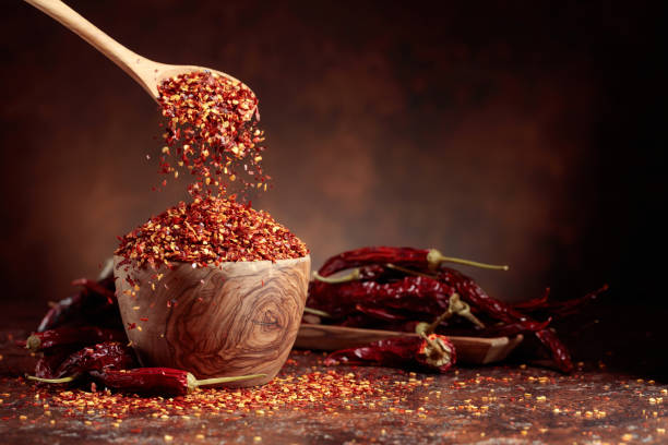 istock Chilli flakes are poured into a wooden dish. 1437176525