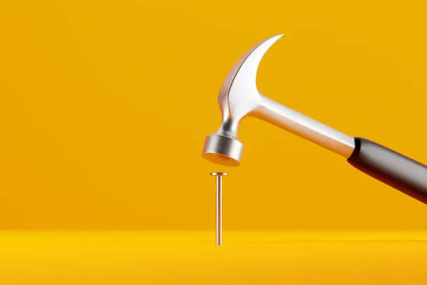 Claw hammer with black plastic handle hitting a nail on yellow background. 3D rendering.