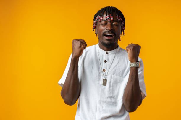 istock Young african man standing over yellow background doing winner gesture 1437178572
