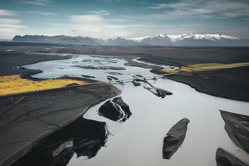 Aerial view on a road crossing the glacial river in South Iceland. Katla volcano (Myrdalsjokull glacier) in the background.