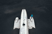 Man Standing On Abandoned DC-3 Airplane Wreckage