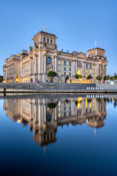 The Reichstag in Berlin at dawn reflected in the river Spree
