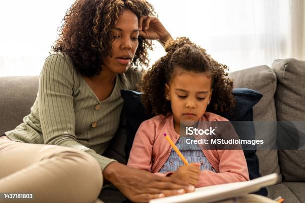 Mother is helping her daughter with her homework
